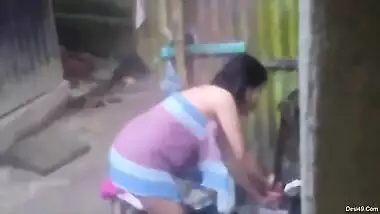 Naked Desi woman washes XXX assets outdoors not knowing about camera