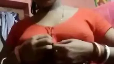 Aroused Desi wife slowly takes red top off to expose boobs for XXX fans